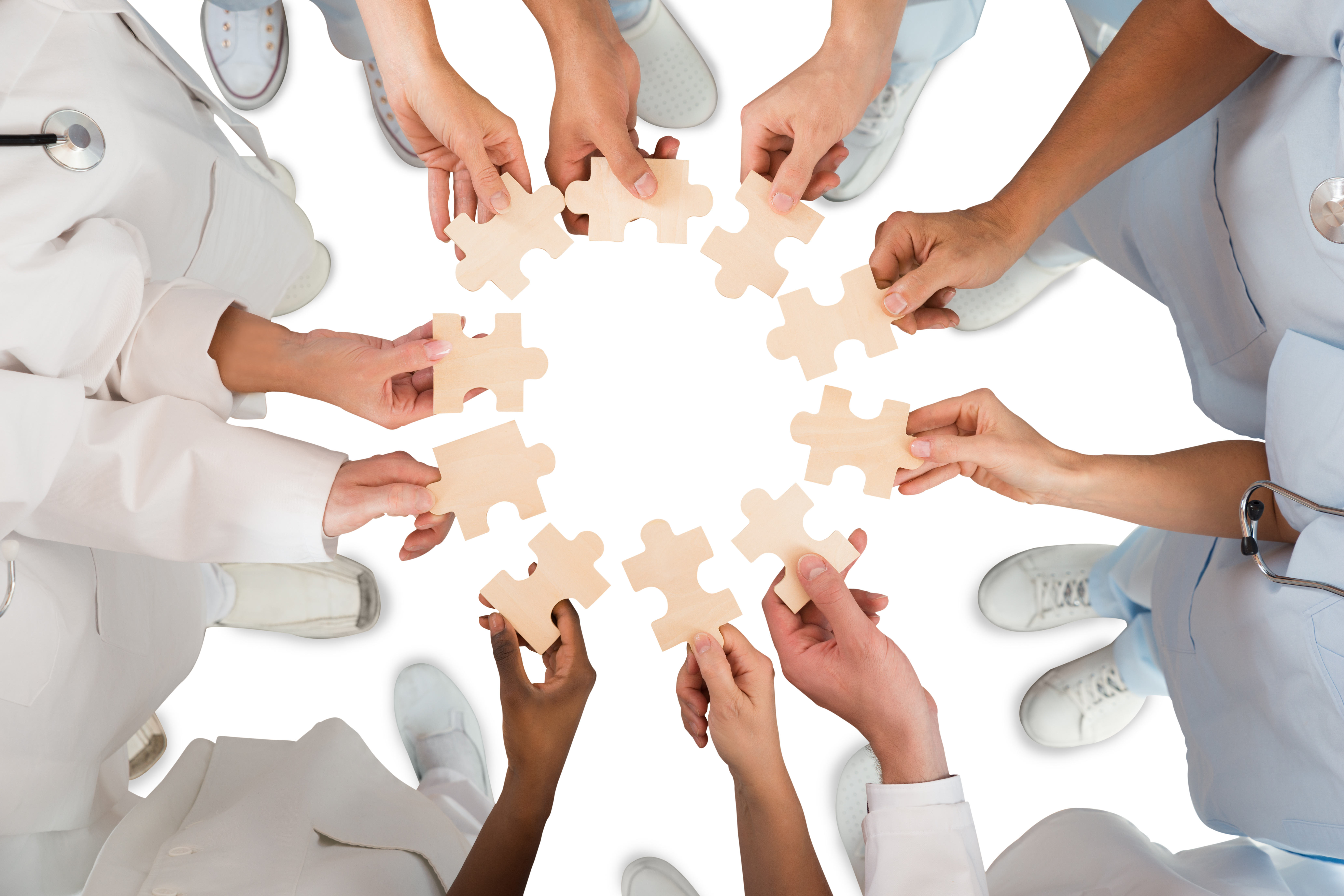 Medical Team Holding Jigsaw Pieces In Huddle Medical Team Holding Jigsaw Pieces In Huddle
