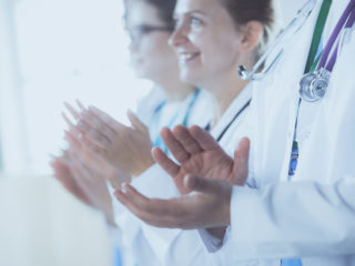 Medical team clapping their hands during a meeting